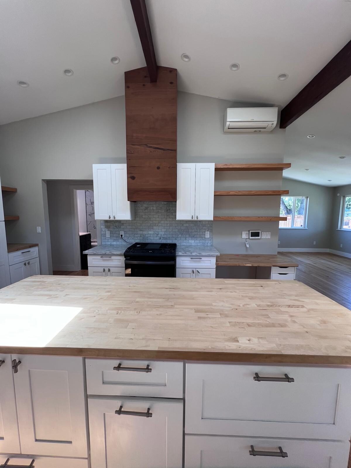 Home A — kitchen with butcher-block island and reclaimed wood range hood