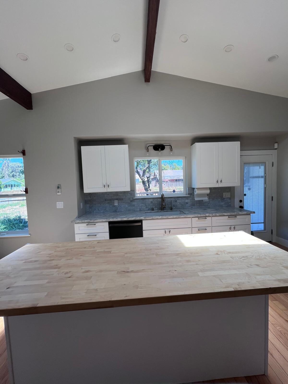 Home A — kitchen with marble counters and farmhouse sink wall