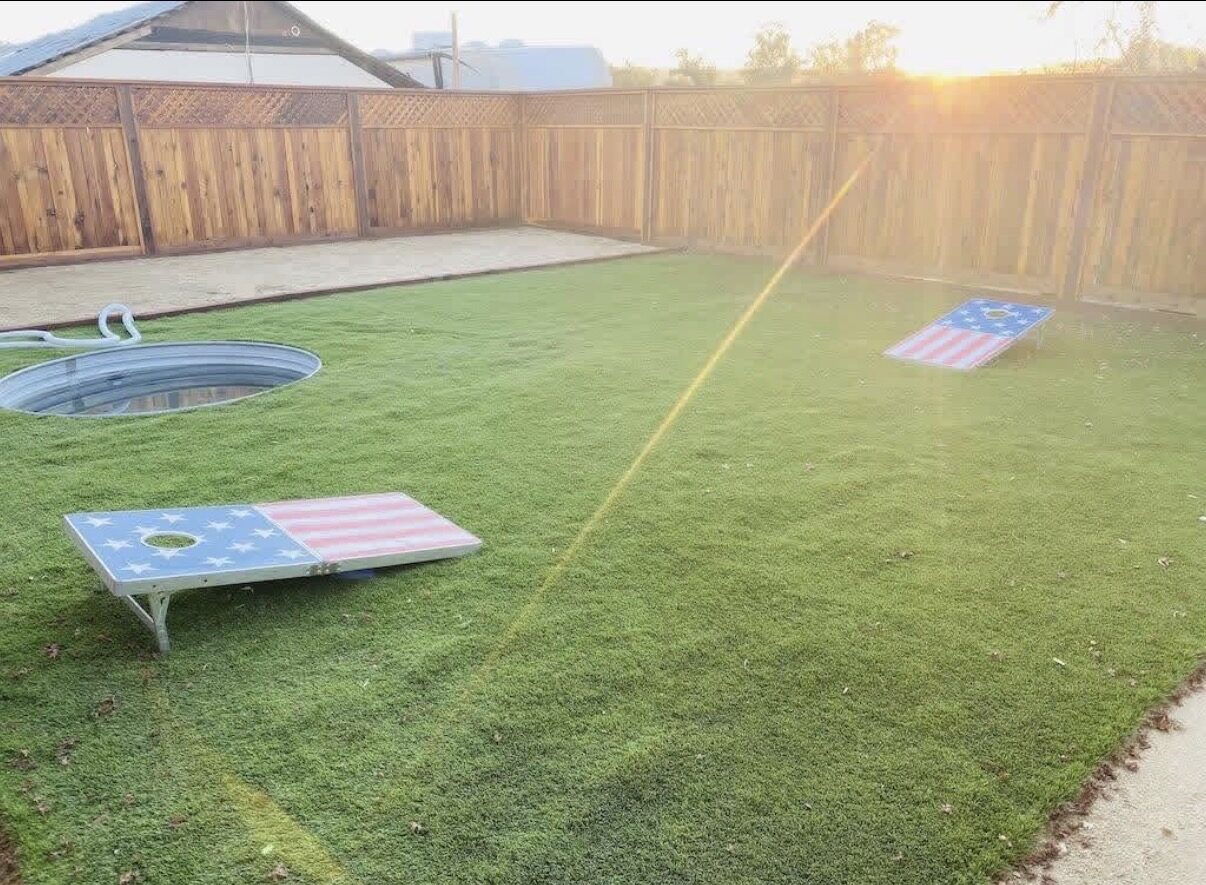 Lawn with cold plunge and cornhole